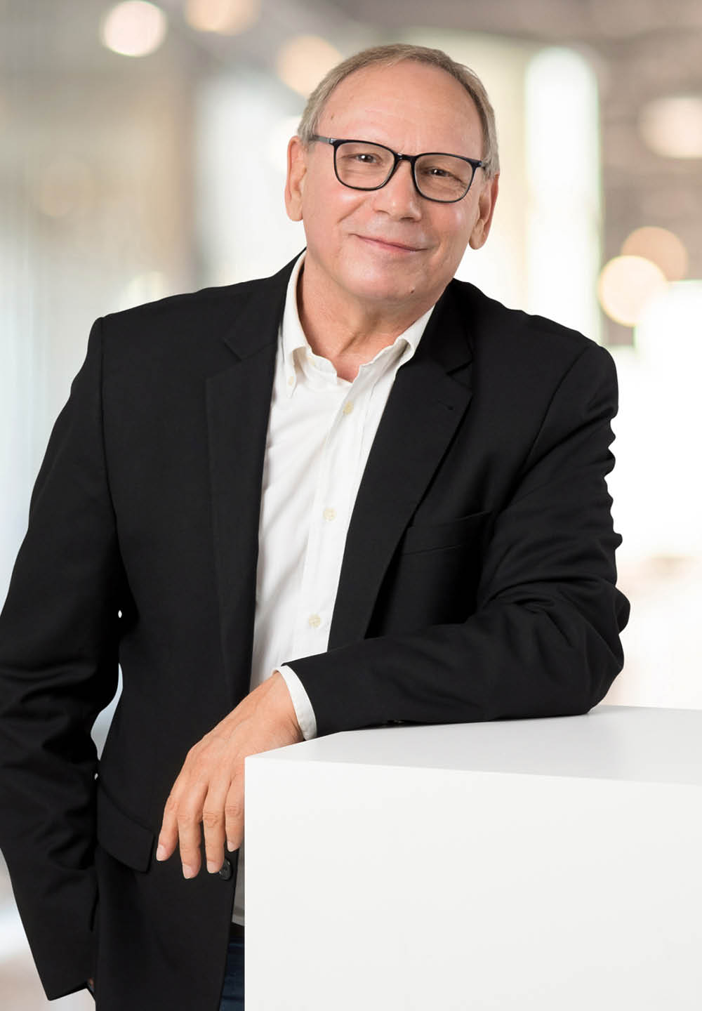 Danny Jung stützt sich mit dem Ellenbogen auf einem weißen Würfel auf